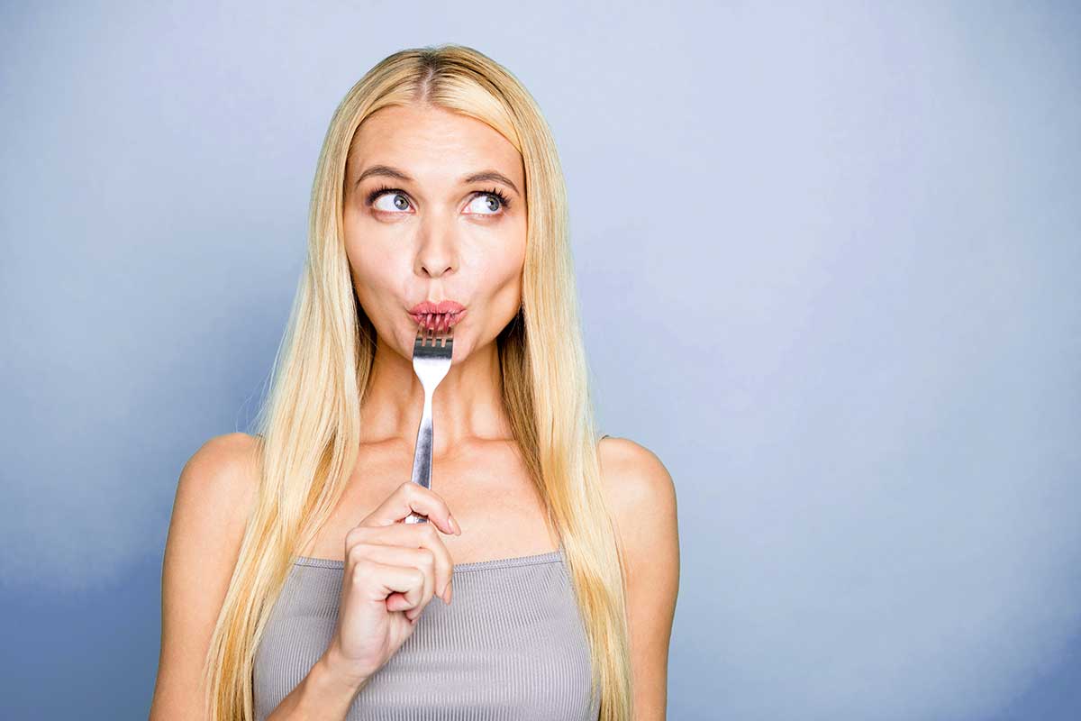 a woman with a fork on her mouth